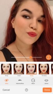 Print de uma selfie de uma mulher com cabelos vermelhos mostrando a ferramenta Relight do AirBrush 