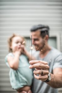 Pai segurando seu filho com uma vela na mão