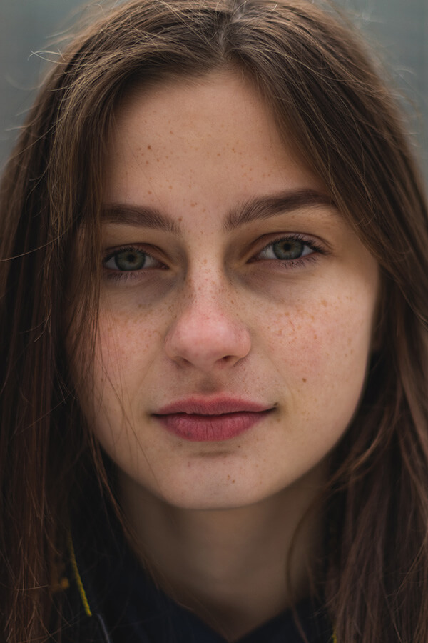 Foto de uma mulher com olhos verdes e sardas. 