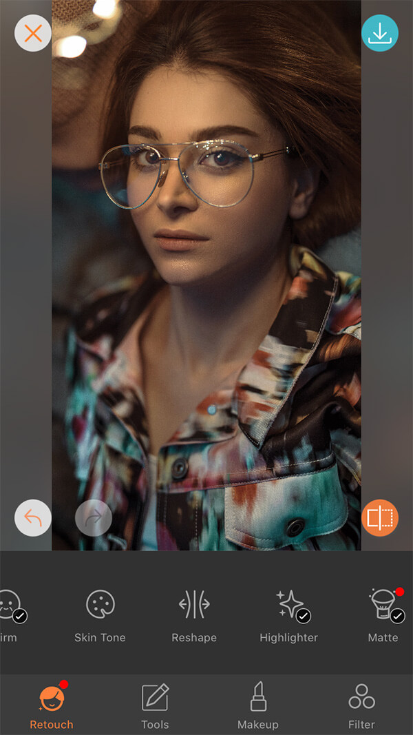 closeup of woman with brown hair and glasses wearing a colorful shirt