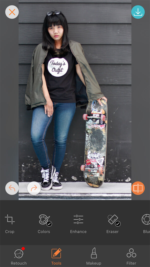 woman in black tshirt with slogan "Today's Outfit holds skateboard in front of black wall