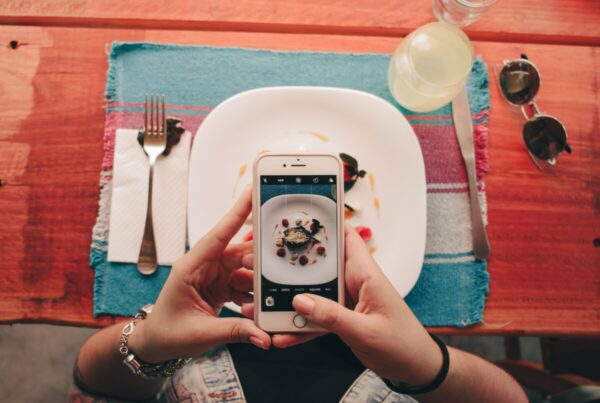 foto tirada de cima mostrando a tela de um celular tirando foto de um prato de comida