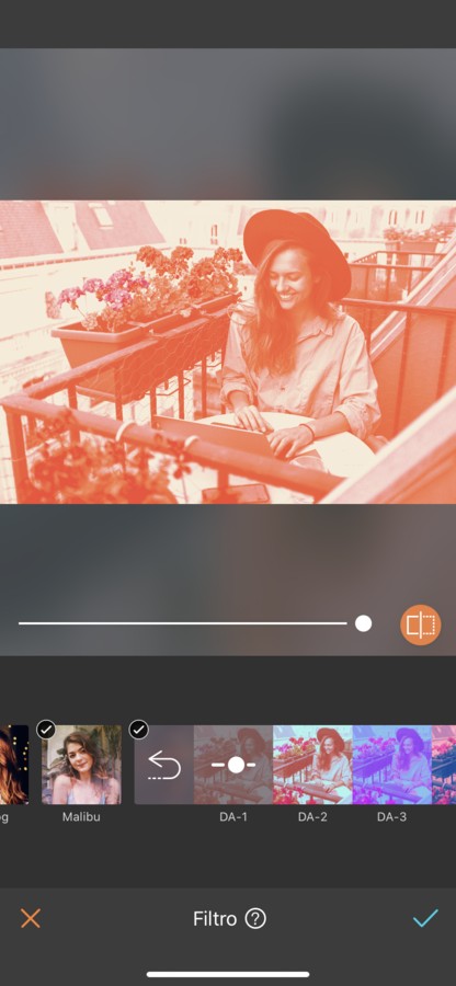 mujer rubia con sombrero trabajando en un balcón en Paris. La imagen tiene un filtro naranja.
