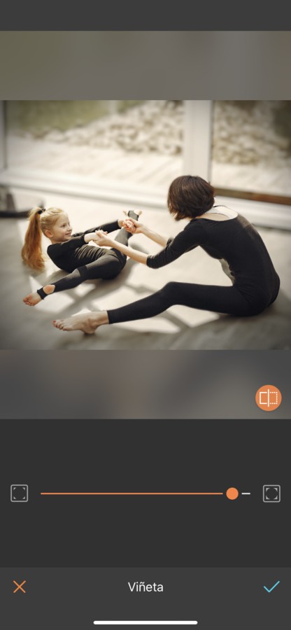 Foto de mamá practicando ballet o gimnasia con su hija. Ambas están vestidas con un payasito negro y están haciendo estiramientos.