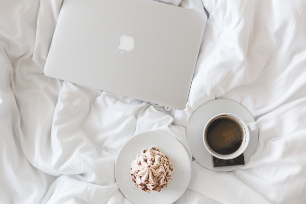 flat lay of closed Mac Book pro, muffin and coffee