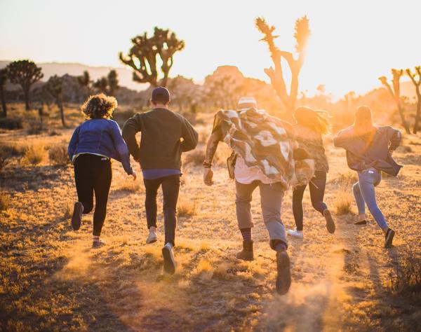 a group of people running in the desert