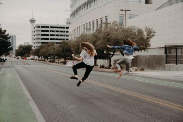 two women jumping in an empty street