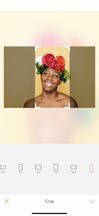 Picture of bald black woman with a crown of flowers being edited by AirBrush with the Crop Tool
