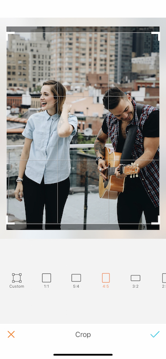 Picture of a woman and man singing and playing in a rooftop being edited by AirBrush with the Crop Tool