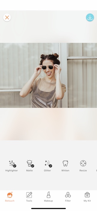 laughing woman wearing sunglasses in front of light background