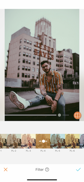 man sitting on rooftop in front of city skyline