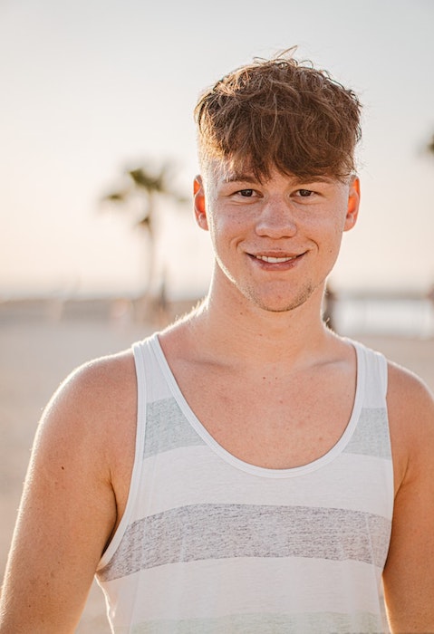 young man in white and grey tank top at the beach