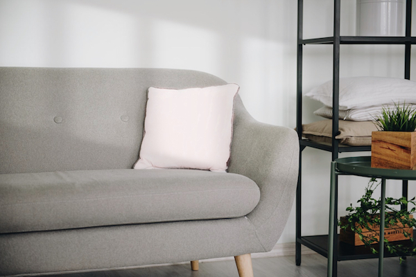 pink pillow on grey couch