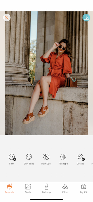 woman wearing orange dress posing in front of pillars