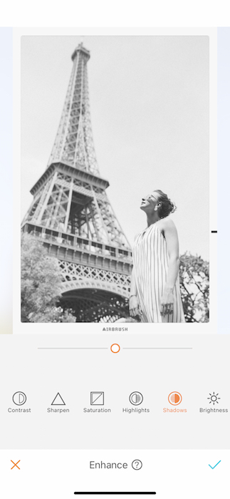 black and white photo of white woman standing in front of the Eiffel Tower