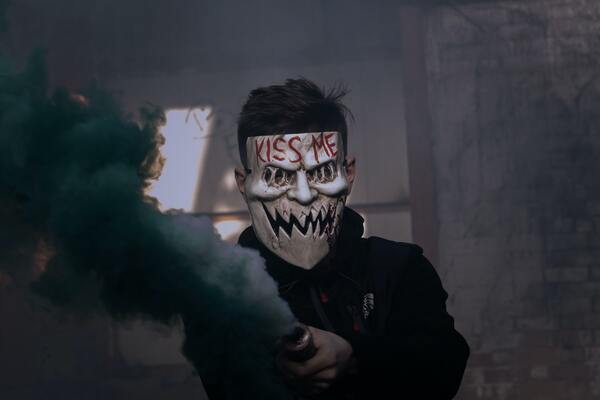 foto de um homem com uma máscara escrita Kiss Me