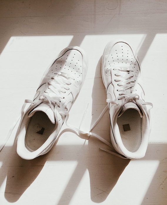 brightly lit photo of white sneakers on a white surface