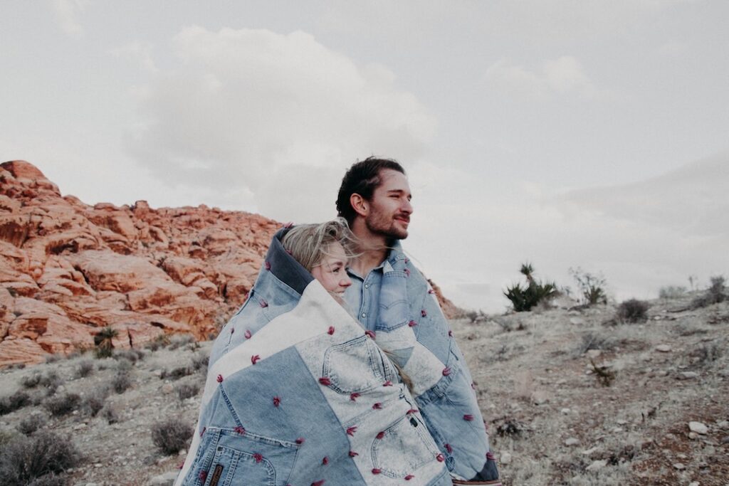 2020 AirBrush edit of couple in desert wrapped in a blanket
