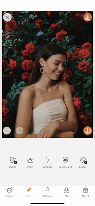 Picture of a brunette with flowers in the background being edited by AirBrush with Blur Tool