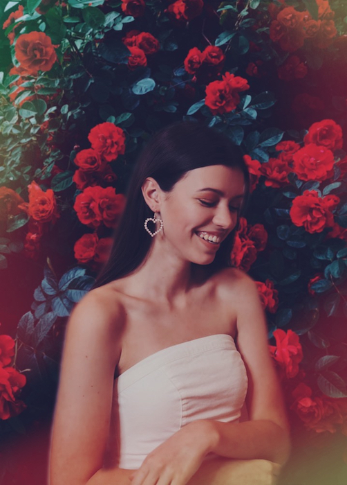 Picture of a brunette with flowers in the background
