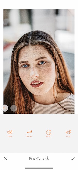 Picture of a white woman with freckles being edited by AirBrush with Fine-tune tool