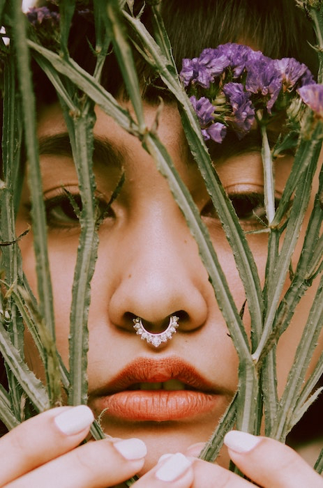 Picture of a woman with flowers close to her face