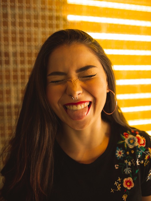 Picture of a brunette showing her tongue being edited by AirBrush