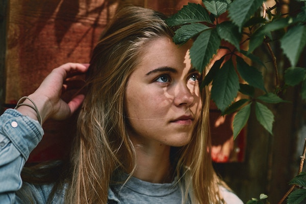 Picture of a blonde girl with plants in her eyes being edited by AirBrush