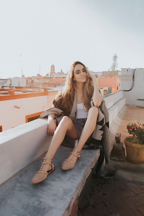 woman sitting on a rooftop overlooking the city