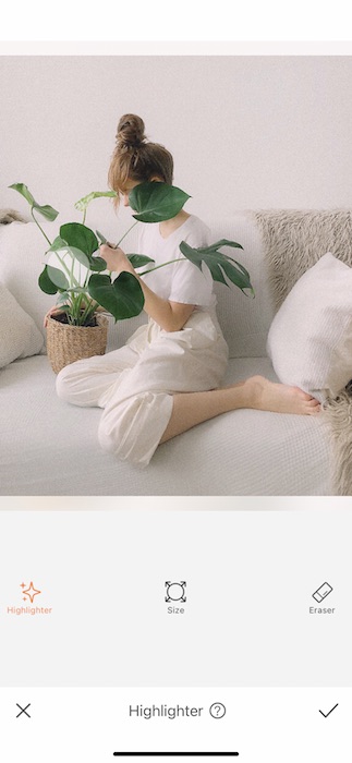 woman sitting on a white couch holding a plant