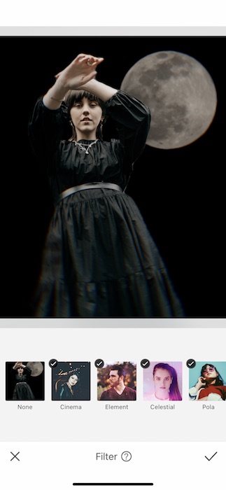 woman wearing a black dress standing in front of the moon