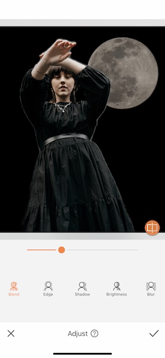 woman wearing a black dress standing in front of the moon
