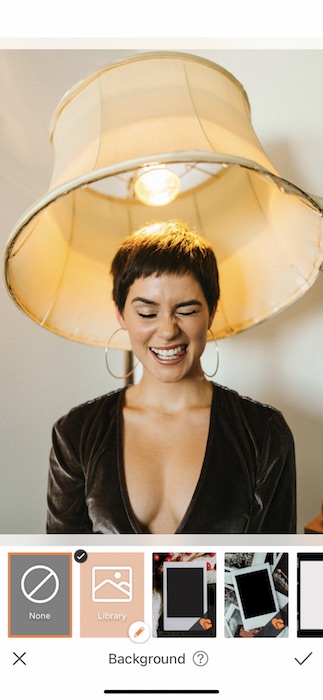 woman with a pixie haircut making a silly face while sitting under a lamp