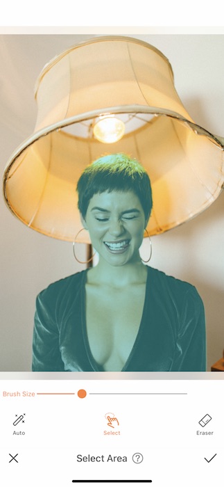 woman with a pixie haircut making a silly face while sitting under a lamp