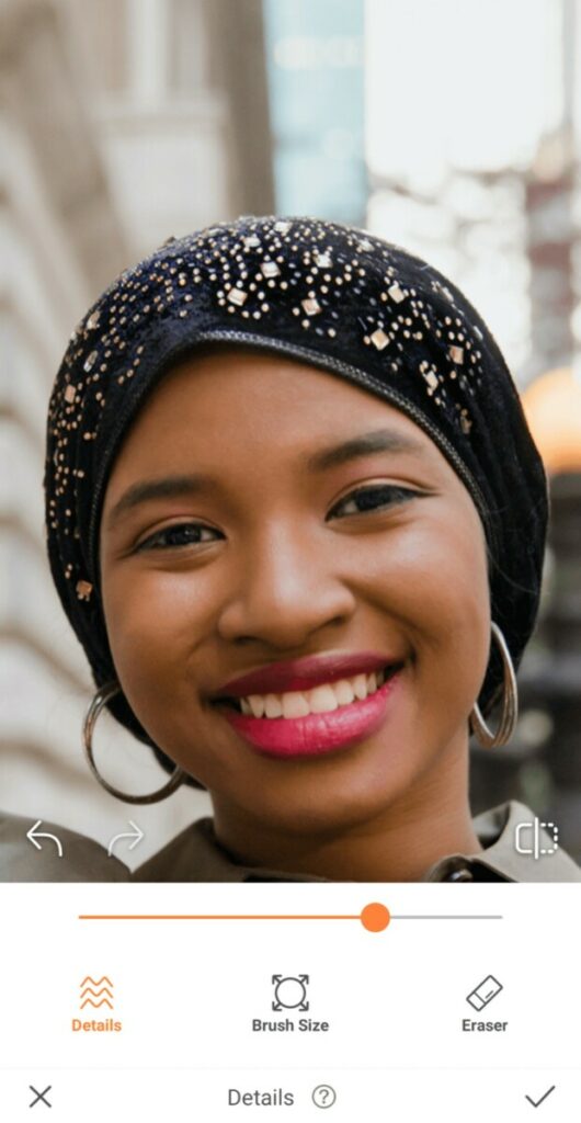 closeup of black woman wearing black head scarf and pink lipstick