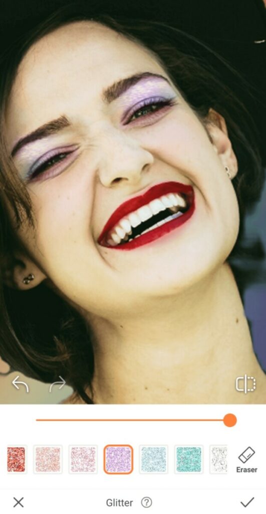 closeup of a laughing woman with red lipstick and glitter on her eyelids for Pride edit