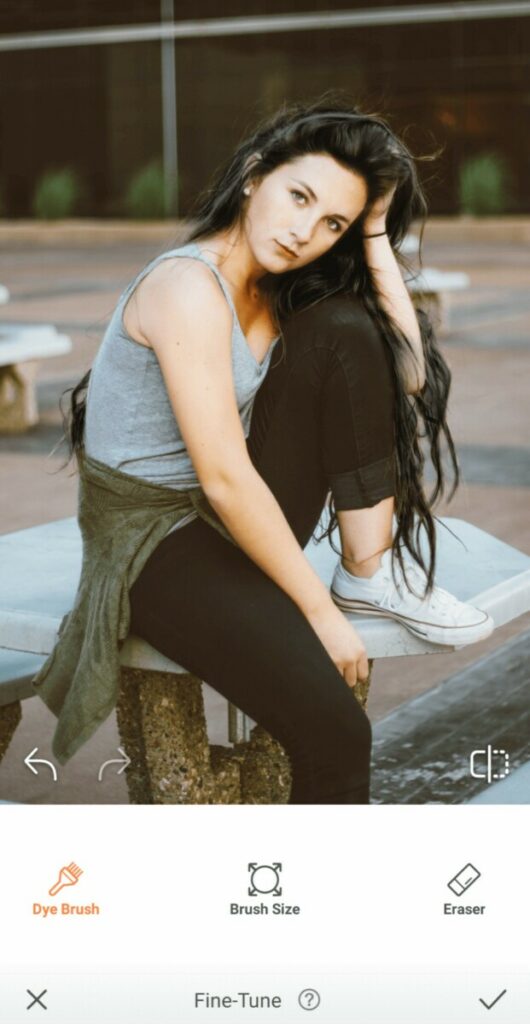 woman with black hair wearing grey tank top and black jeans