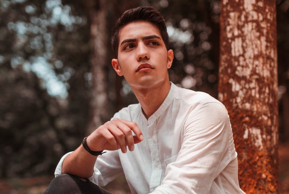 Capricorn horoscope edit of a man wearing a white shirt sitting outdoors