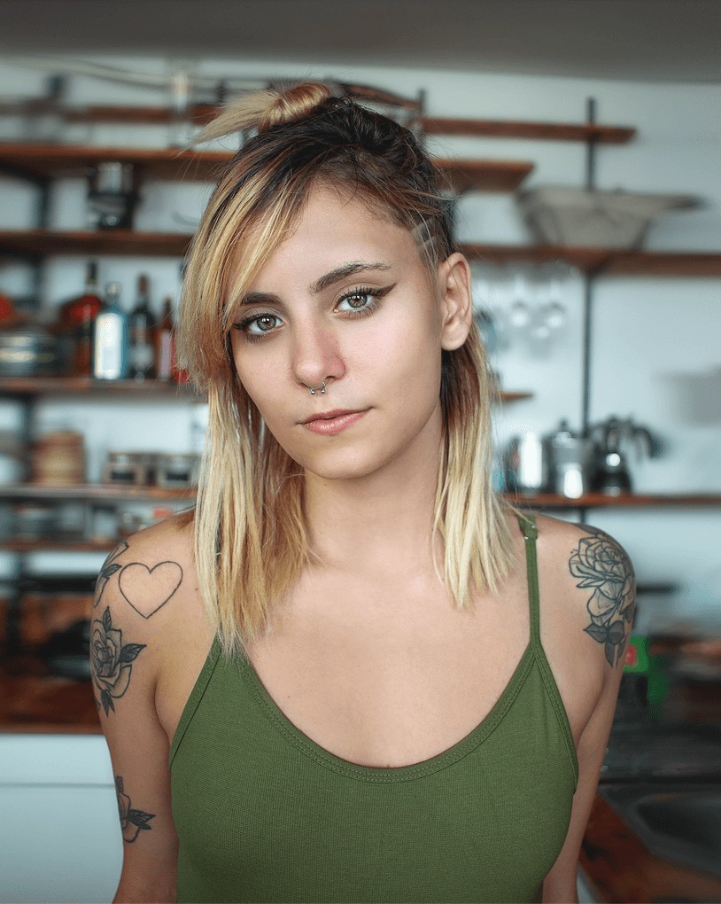 woman with tattoos wearing a green top
