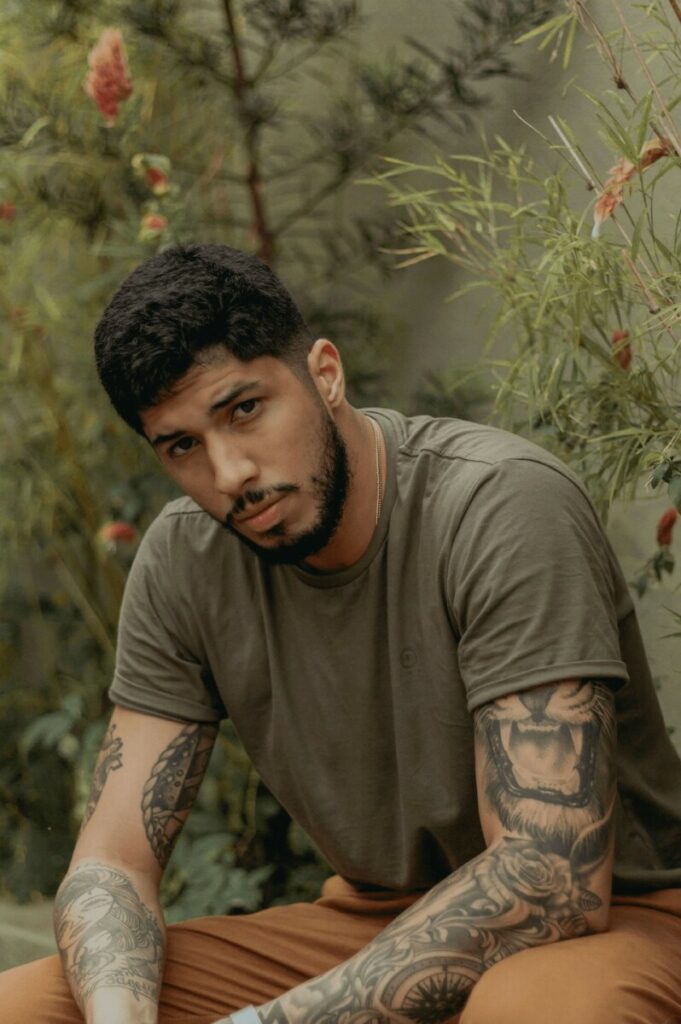 man wearing a green t-shirt with arm tattoos