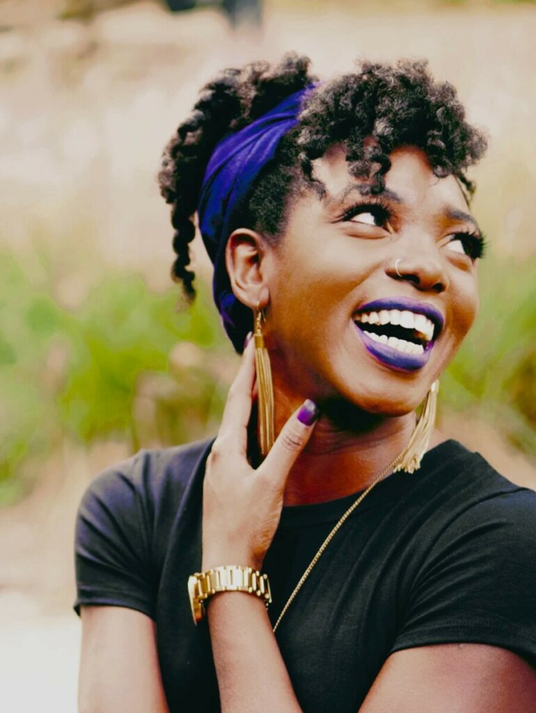 woman with purple nail polish and purple lipstick wearing a purple headband