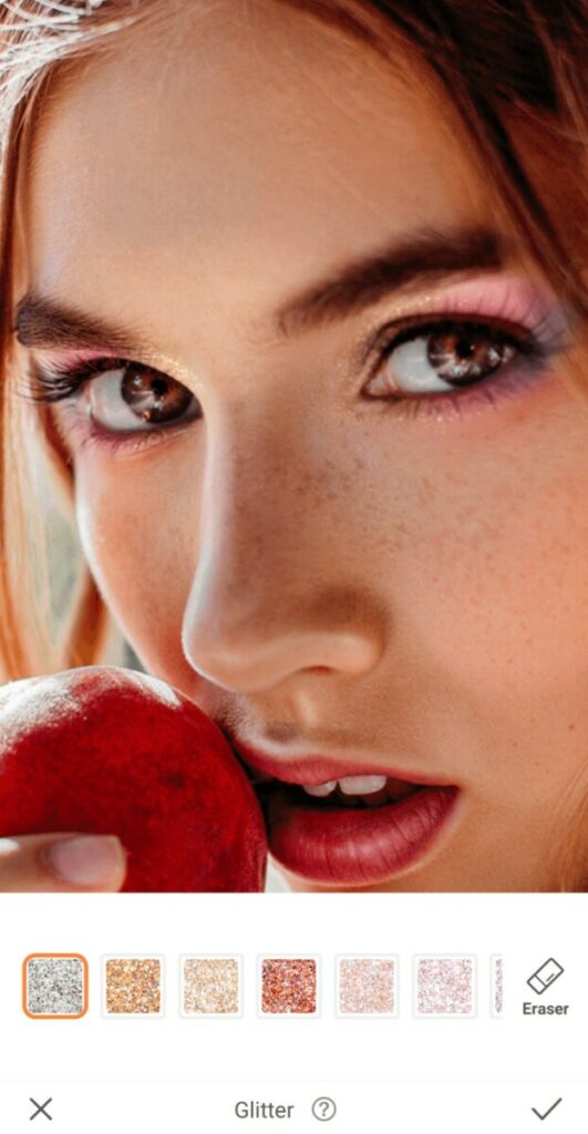 closeup of woman with colorful eye making holding an apple