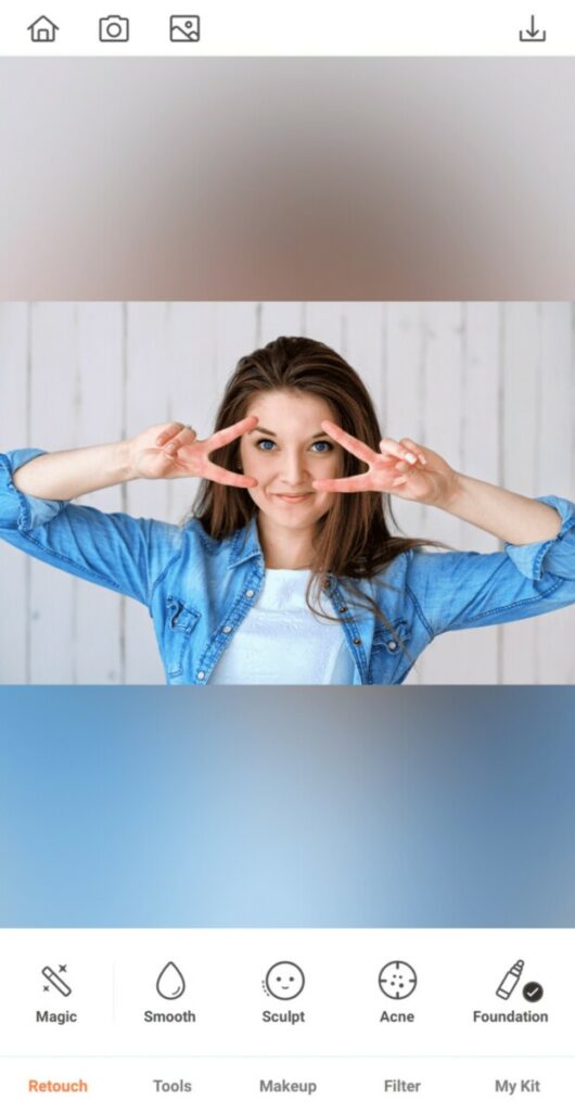 woman wearing chambray shirt making the peace sign over her eyes