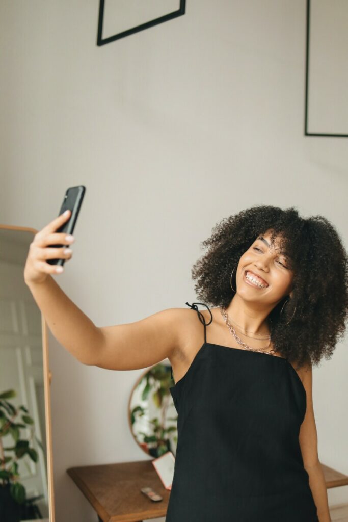 woman with curly hair takes a selfie