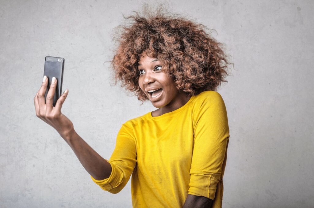 woman in yellow top takes a selfie