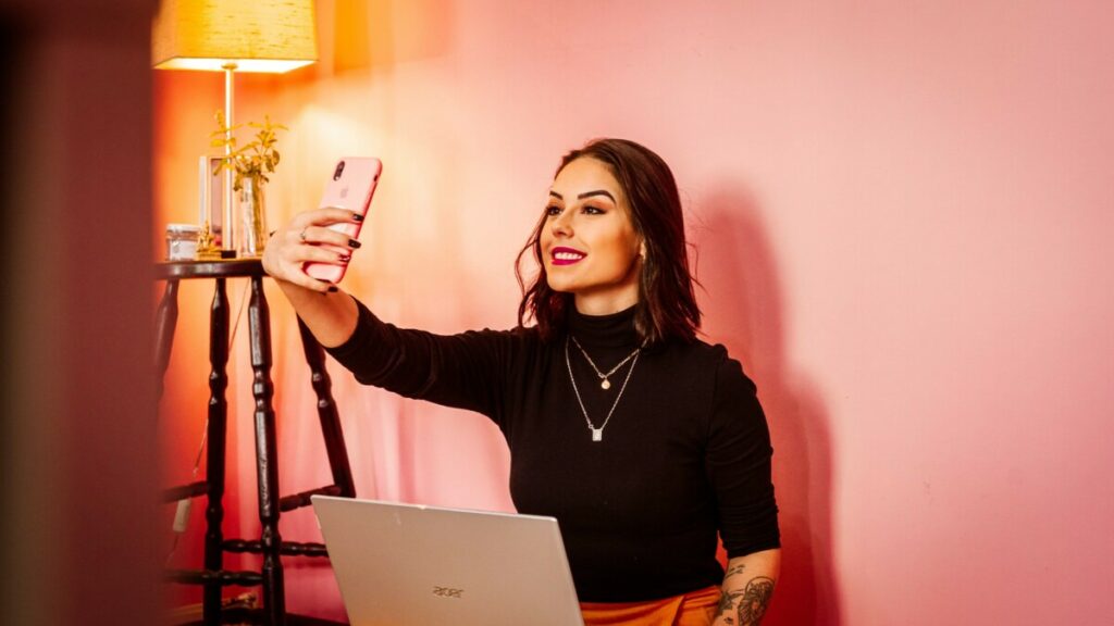 woman seated at a desk takes a photo