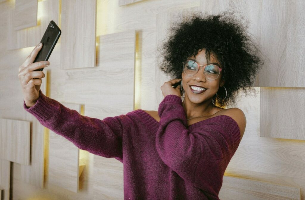 smiling woman in purple sweater takes a photo