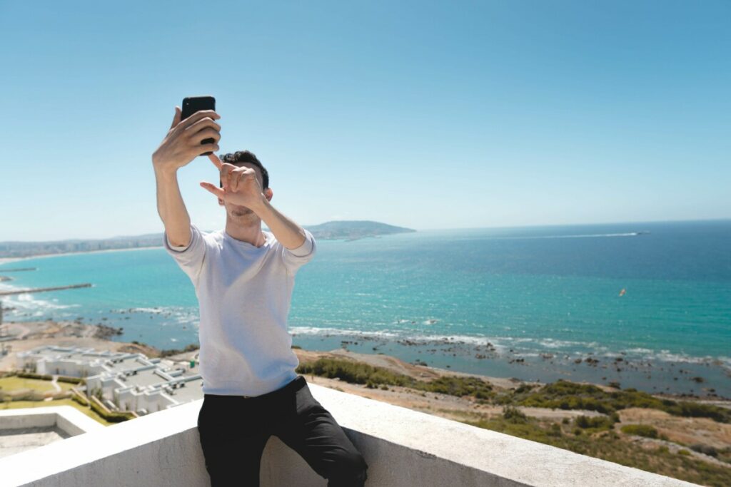 man takes photo in front an ocean view