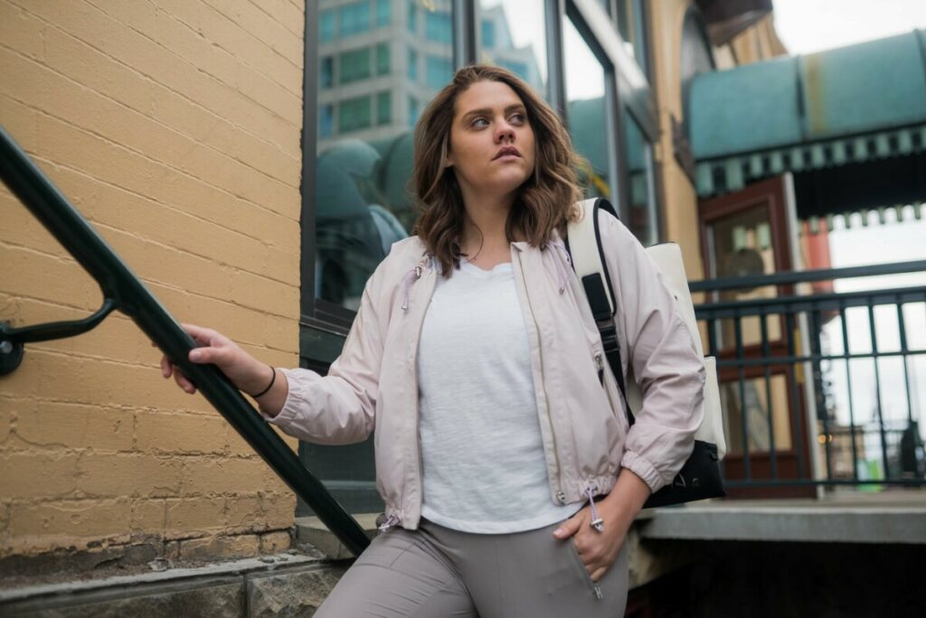 fall fashion look with woman wearing gray pants and a pink jacket