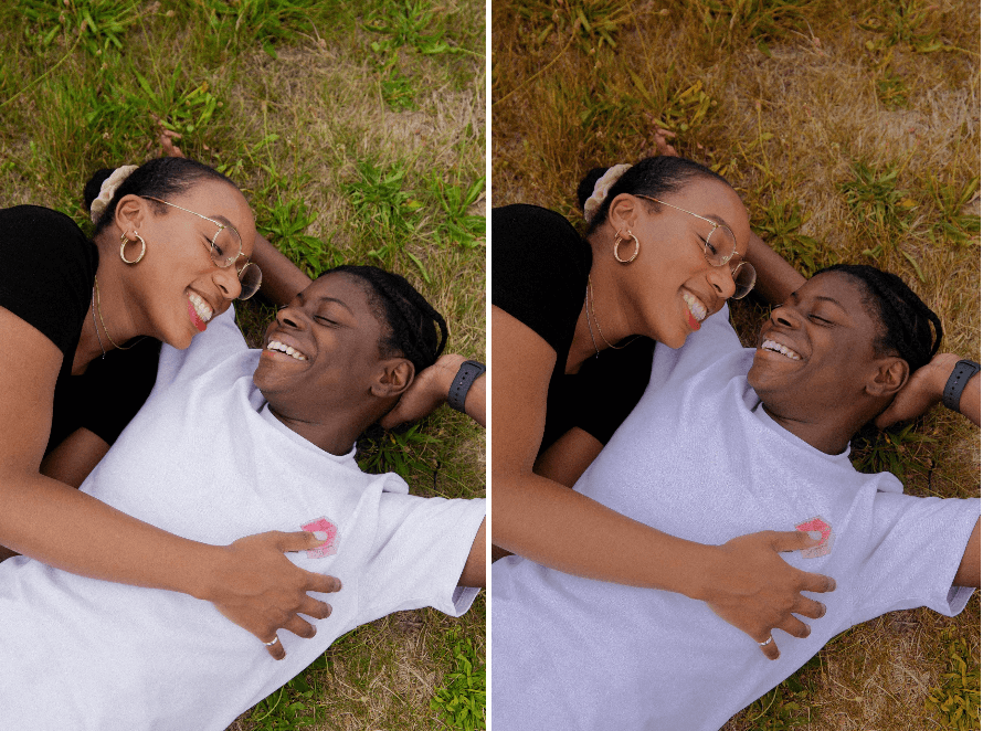 black couple lying down on green grass smiling at each other